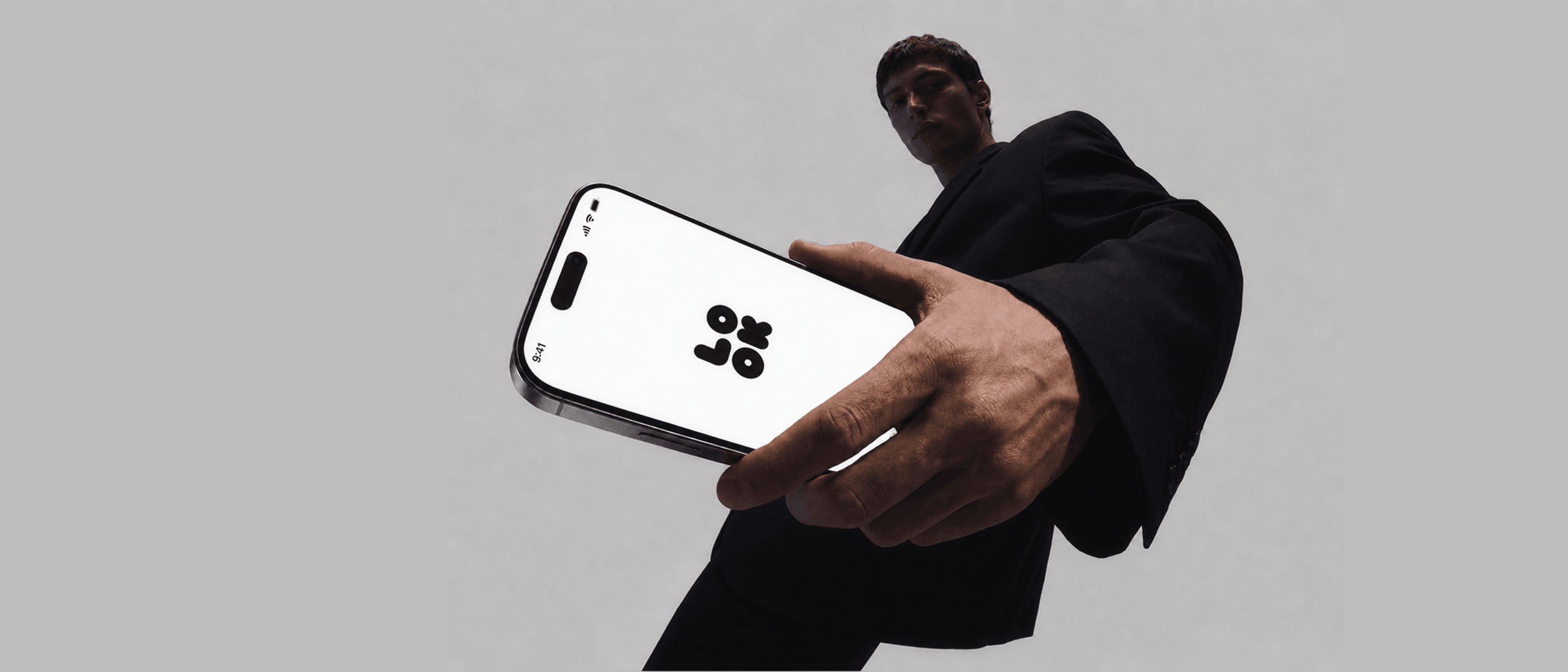 Person holding iPhone with Lookscope logo, editorial portrait